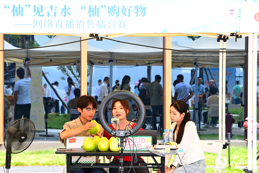 活動現場，參加網絡直播銷售擂臺賽的主播們通過直播助力井岡蜜柚銷售。人民網 朱海鵬攝