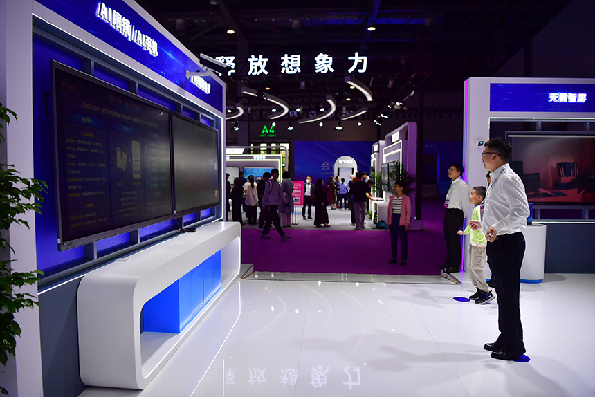 中國電信展位上，工作人員帶領小朋友做互動游戲。人民網記者 時雨攝