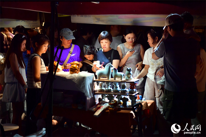 游客在春秋大集的攤位上挑選心儀的瓷器。人民網記者 時雨攝