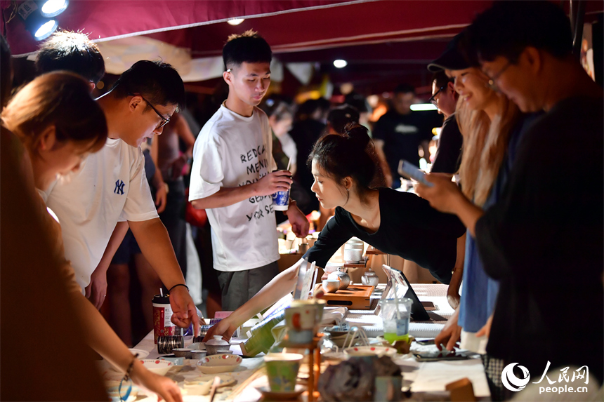 游客在春秋大集的攤位上挑選心儀的瓷器。人民網記者 時雨攝