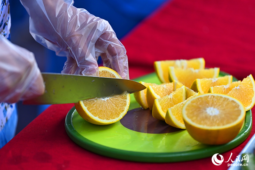 采購商和游客前來洽談臍橙訂單，品嘗臍橙特色美食。人民網 朱海鵬攝