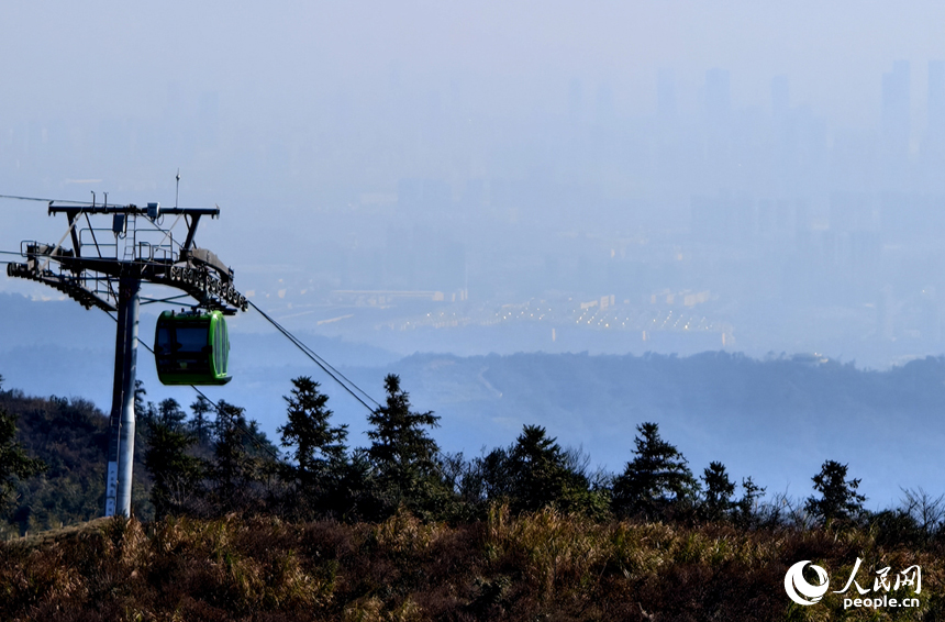 站在梅嶺云端索道的上站處遠眺，隱約可見紅谷灘區的高樓。人民網記者 時雨攝