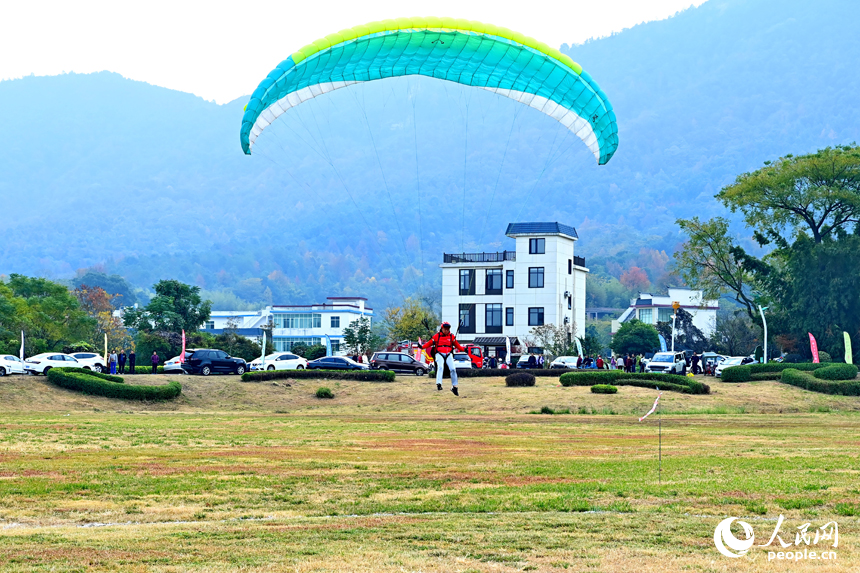 南康區龍回鎮布谷寨航空飛行營地，動力傘編隊、滑翔傘表演和比賽吸引眾多游客前來觀看。人民網記者 朱海鵬攝